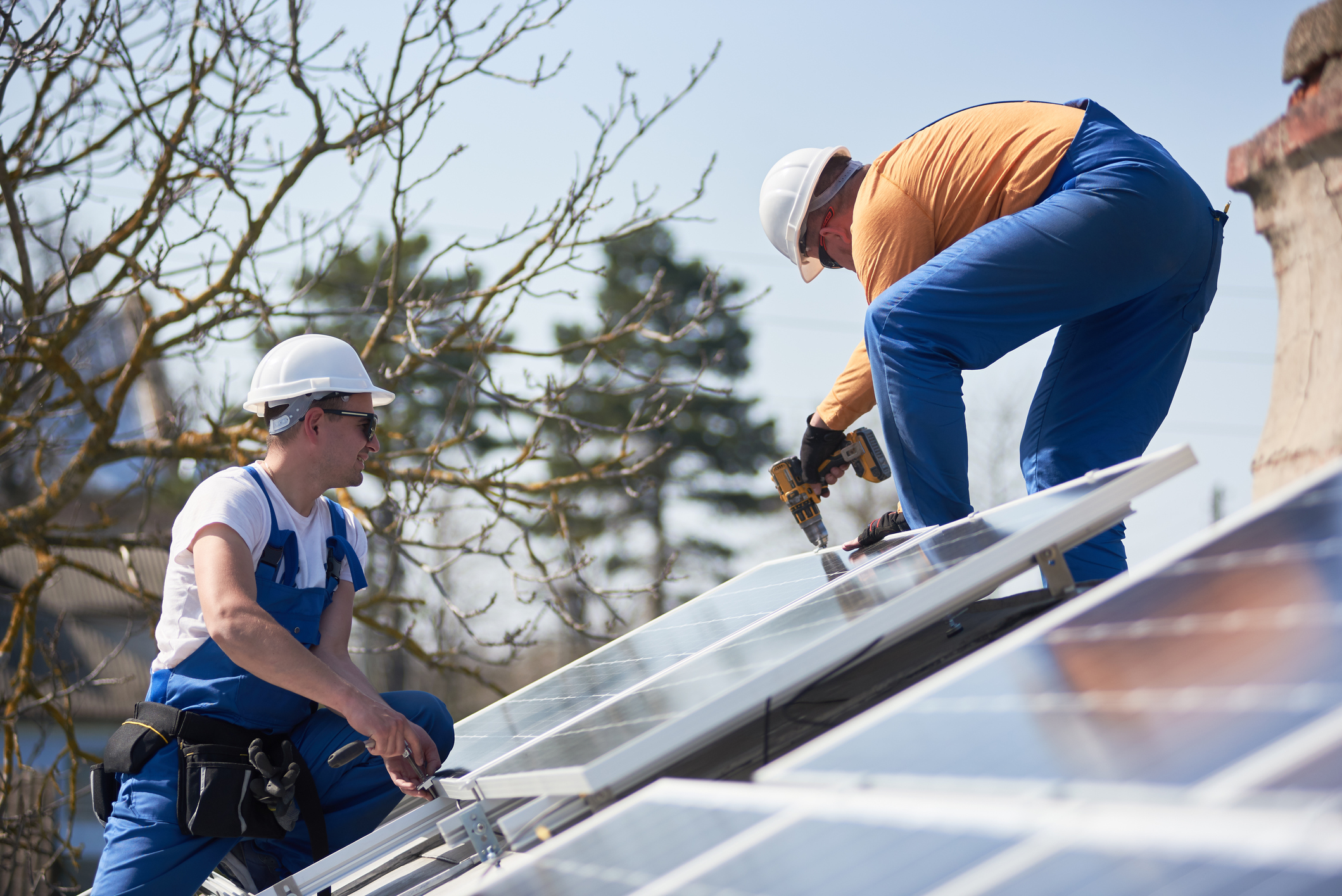 Handwerker auf Dach mit PV-Anlage im Aargau